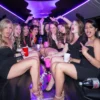 A group of women in elegant black dresses enjoying a luxurious ride in a limousine.